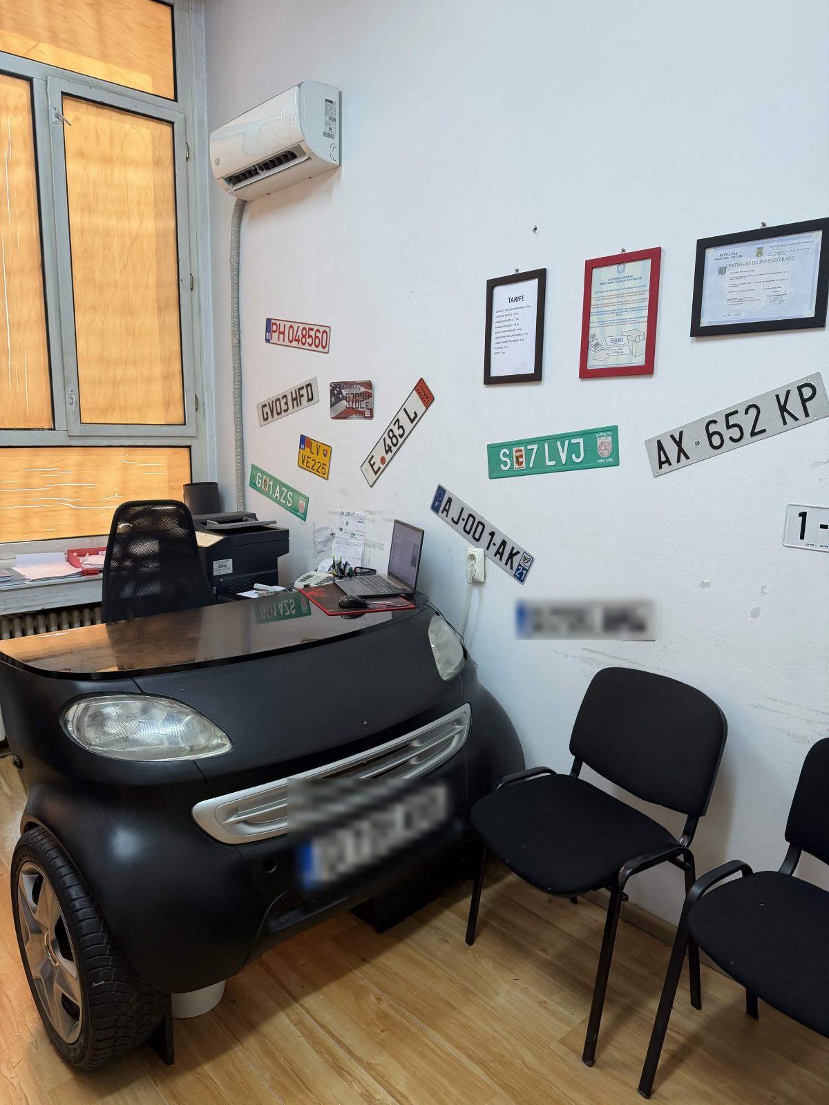 Biroul Auto AMA Intermed: un birou făcut dintr-o mașină și un perete cu plăcuțe de înmatriculare